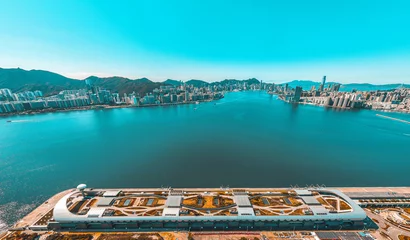 Rolgordijnen Panoramisch luchtfoto van de stad Hong Kong in oranje en groenblauw kleurtoon © YiuCheung