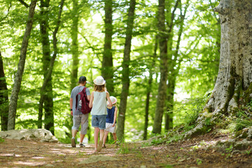 Father and daughters following a footpath around La Verna Sanctuary, Chiusi della Verna, in Casentino secular forest, one of the largest forest in Europe. Foreste Casentinesi, Italy.
