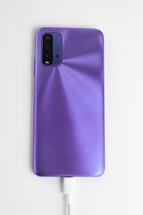 Purple cell phone connected to USB cable type C - Charging
