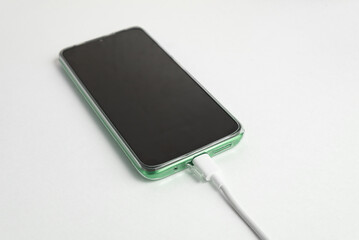 Green cell phone connected to USB cable type C - Charging