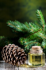 Fototapeta premium Cedar and spruce essential oil in small glass bottle on wooden background.
