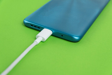 Blue cell phone connected to USB cable type C - Charging