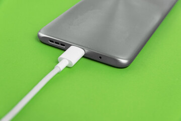 Grey cell phone connected to USB cable type C - Charging