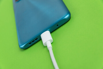 Blue cell phone connected to USB cable type C - Charging