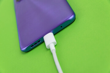 Purple cell phone connected to USB cable type C - Charging