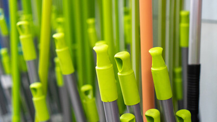 Some broom handles on display on a home appliance store shelf.