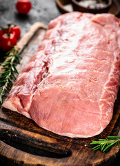 Raw pork with rosemary and tomatoes. On a black background. High quality photo