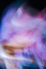 Blurred image of young female lying on the floor with a pink purple dress. Concept of female psychosis, panic attack, addiction and mental disorders personality.