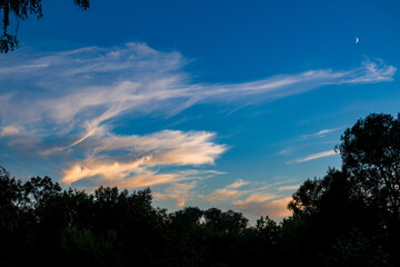 White cirrus clouds on a blue sky background