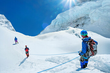Climbers tied with rope on descending from a summit of mountain peak in Nepal enjoying the...