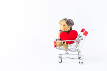 Little bear holding red heart in shopping cart with space on white background, valentine sale, love and romance, relationship