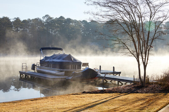 A boat dock with covered boat and jetski on a southern lake in winter USA