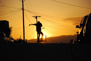 Skater boarder Doing Ollie Trick  During Sunset