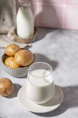 A glass of potato milk on the table. Plant-Based Potato Milk Alternative, Vegan Milk vertical photo