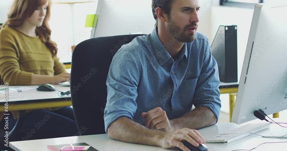 Poster focused businessman typing on his computer doing research in the office. young professional man usin