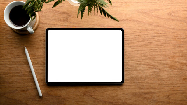 Simple office desk with tablet screen mockup on wooden background.