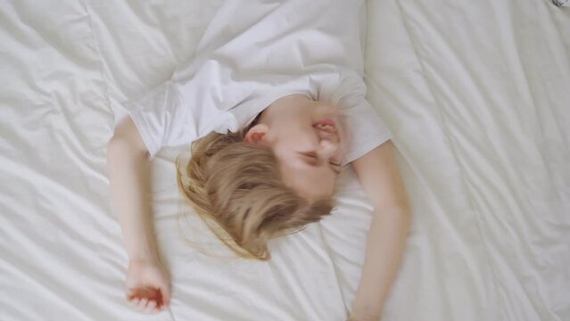 view top. a little girl laughs with tickling on the bed. games of children