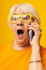 Photo of retired old lady happy lifestyle in yellow t-shirts with phone isolated background