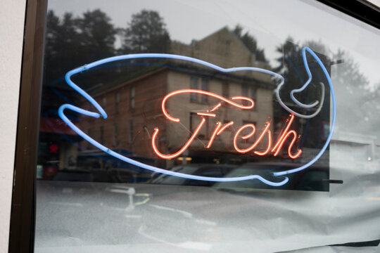 Closeup of a fresh seafood neon sign on the window of a seafood market or restaurant. Seafood industry concept.