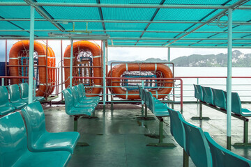 Fototapeta premium Orange inflatable lifeboats on ferry deck for emergencies and maritime accidents. Rescue boat, raft on the roof of a ferry. Life boats on big ship on ocean sea cruise ship.Transportation and safety.