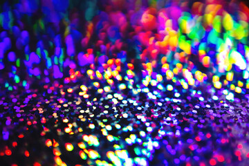 Blurred Neon rainbow glittering lights with glow effect abstract background. Defocused festive...