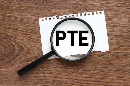 Pearson Tests of English PTE Words on card on magnifier glass business concept