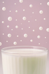 Milk in a transparent faceted glass and drops over it.