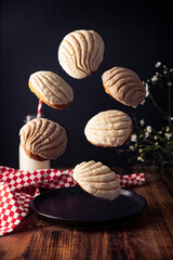 Creative image of Conchas Bread. Mexican sweet bread roll with seashell-like appearance, Usually eaten with coffee or hot chocolate at breakfast or as an afternoon snack.