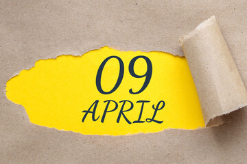April 09. 09th day of the month, calendar date. Hole in paper with edges torn off. Yellow background is visible through ragged hole.Spring month, day of the year concept