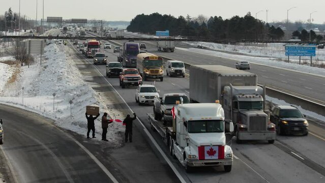 Trucks coming down QEW in Niagara, Ontario apart of the Freedom Convoy 2022. 4K - 29.97fps