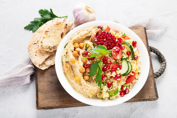 Bulgur and hummus salad on light background.