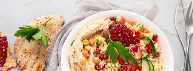 Bulgur and hummus salad on light background.