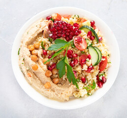 Bulgur and hummus salad on light background.