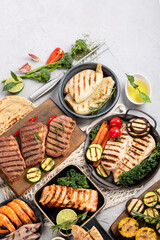 Grilled fish, seafood and meat assortment on light background.