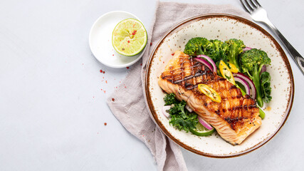 Baked salmon with vegetables on light background.