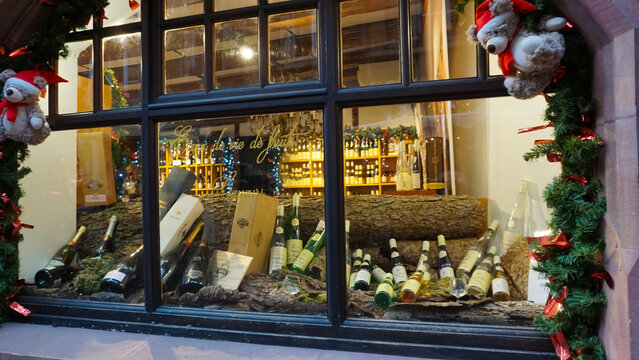 multiple bottles of fine red wines aged on wooden racks near crates at a local store. Alsace Wine Route. Travel and tourism