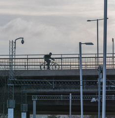 Bicycler on a bridge with pools with lamps and cameras a cold sunny winter day in Stockholm