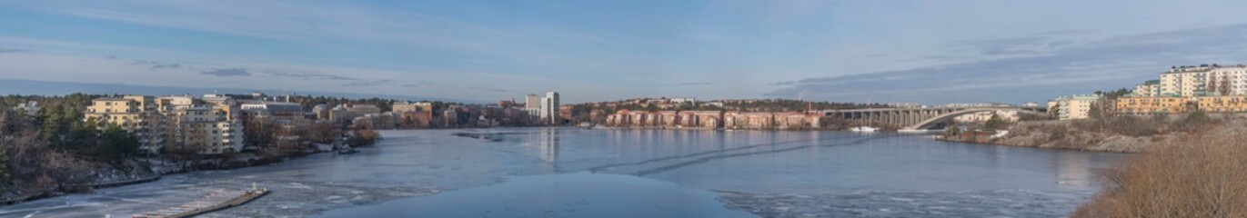 Panorama view over the lake Mälaren, the districts Kungsholmen, Bromma Essingeöarna , bridges, apartment houses on a cliff a cold sunny winter day in Stockholm