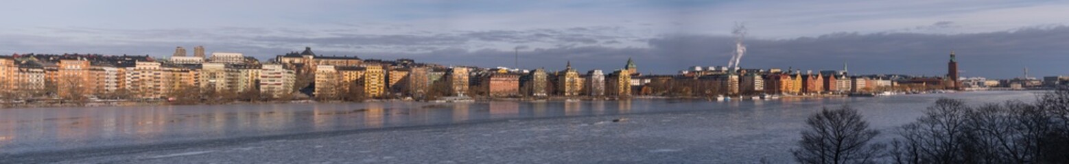 Obraz premium Panorama view over the pier and houses at the district Kungsholmen at the waterfront Norrmälarstrand and an icy bay Riddarfjärden a cold and sunny winter day in Stockholm