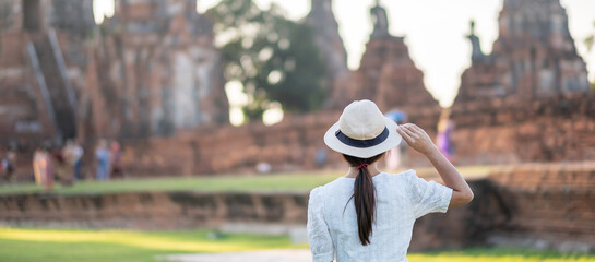 Tourist Woman in white dress visiting to ancient stupa in Wat Chaiwatthanaram temple in Ayutthaya...