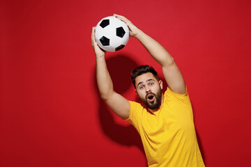 Amazed surprised shocked young bearded man football fan in yellow t-shirt cheer up support favorite...
