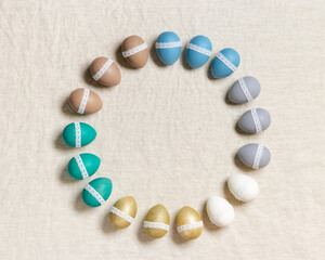 Frame from decorated Easter eggs, pastel colors, blue, green, grey, golden color, traditional holiday food on table background. Colorful chicken egg for Happy Easter. Holiday round framing