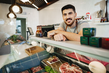 Portrait of confident young salesman standing in butcher's shop