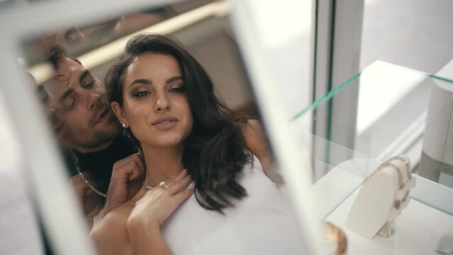 man putting necklace on woman