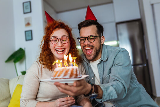 Family couple in party hats celebrating birthday at home - Powered by Adobe