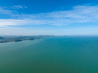 lonely faraway, the empty ocean seperate half frame water and cloud blue sky with little mountain in left side
