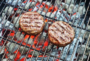 Grilling beef steaks on open grill grate. Photo of meat or barbeque cooking process.