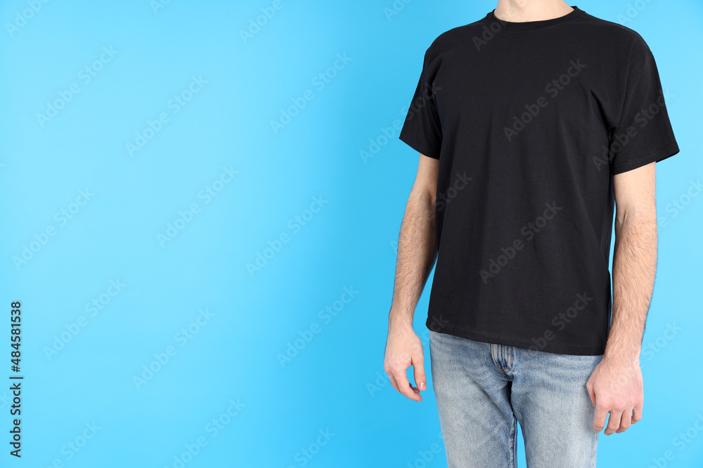 Wall mural Man in blank black t-shirt on blue background - Wall murals