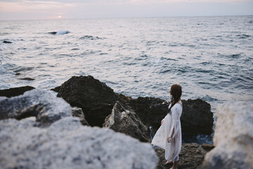Woman in white dress travel stones ocean landscape