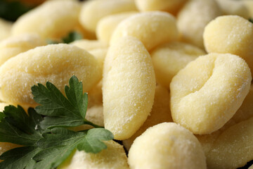 Raw potato gnocchi with parsley, close up and selective focus